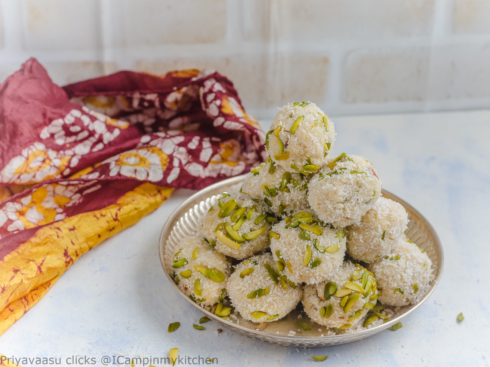 A mountain of freshly made milk powder and coconut ladoo flavored with rose syrup