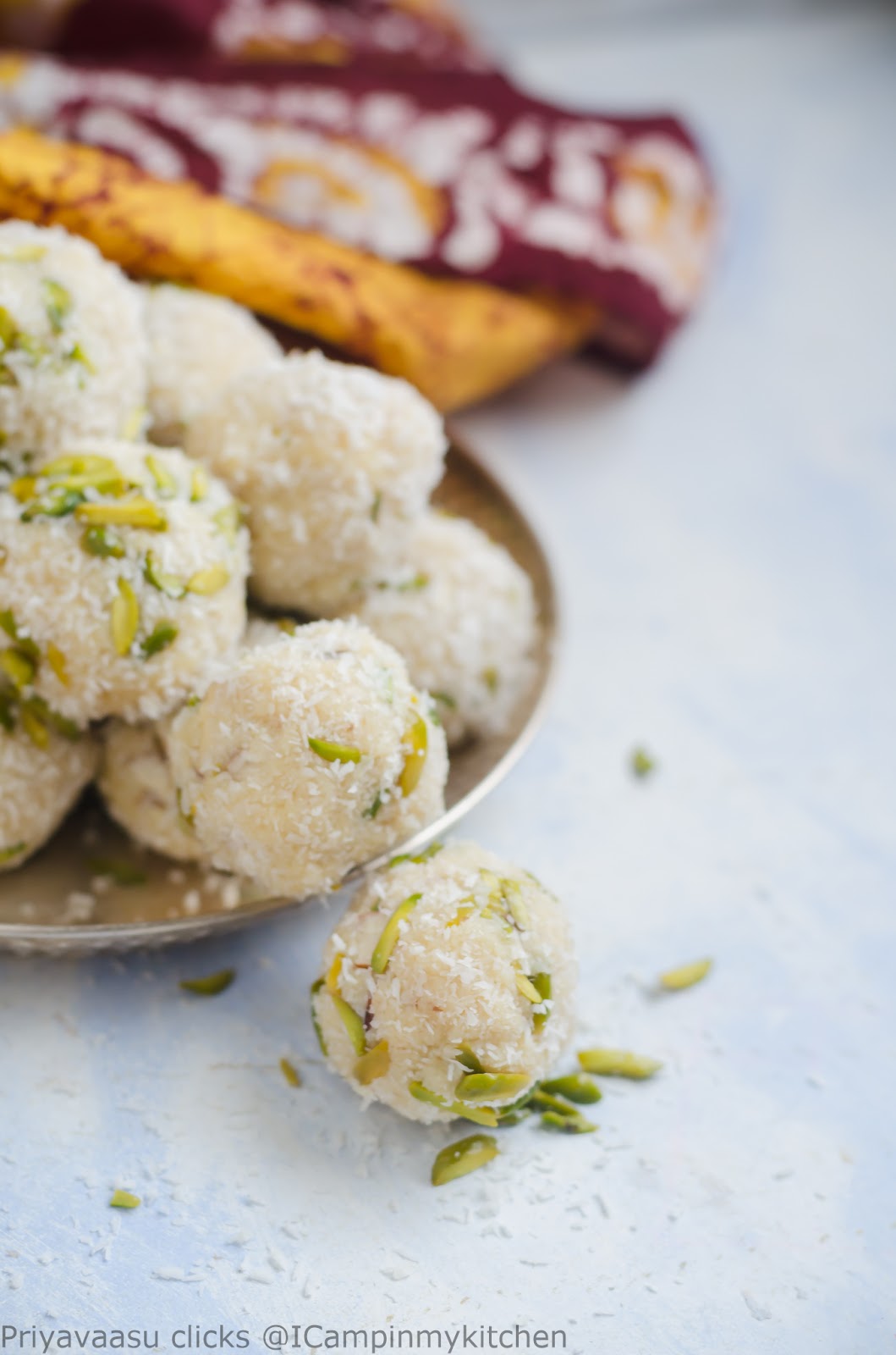 one laddu  on the side of plate. Laddu with rose syrup and coconut