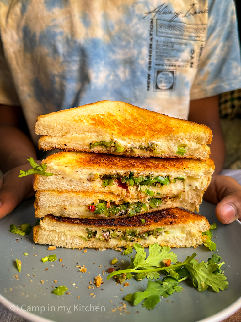 Diagonally cut capsicum cheese sandwich on a plate